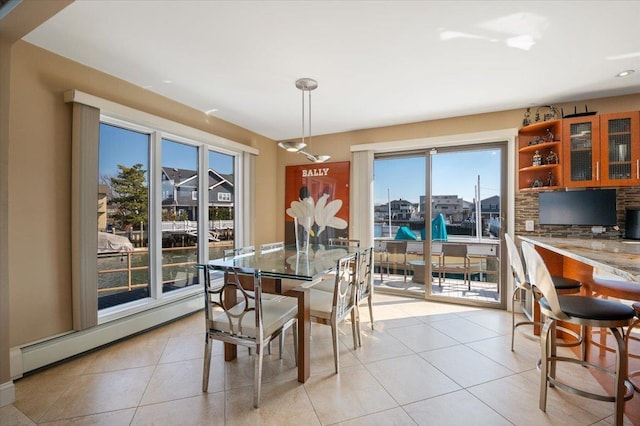 dining area with a baseboard heating unit and light tile patterned floors