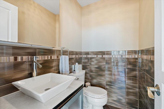 half bathroom with toilet, vanity, and tile walls