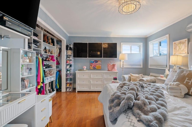 bedroom with light wood-style floors and crown molding