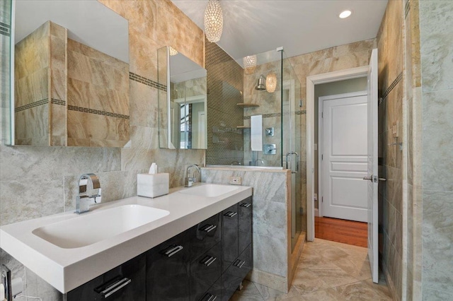 bathroom featuring a sink, tile walls, and a shower stall