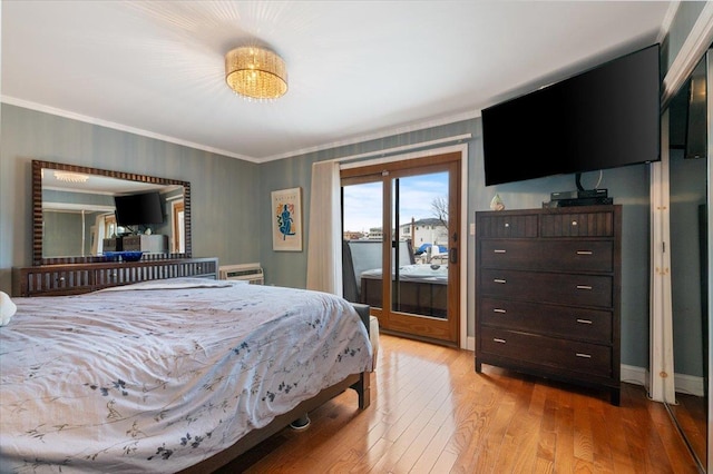 bedroom with access to outside, light wood-style flooring, and crown molding