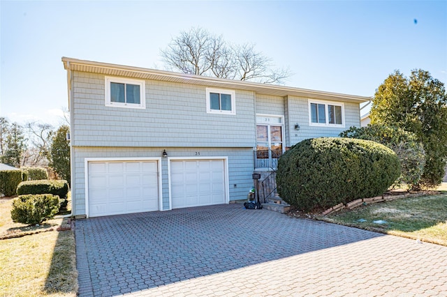 raised ranch with an attached garage and decorative driveway