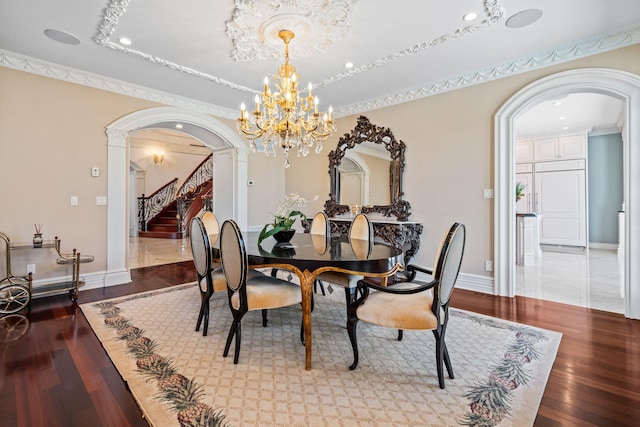 28 Whitney Cir, Glen Cove, NY 11542 - dining space featuring baseboards, stairway, an inviting chandelier, arched walkways, and wood-type flooring