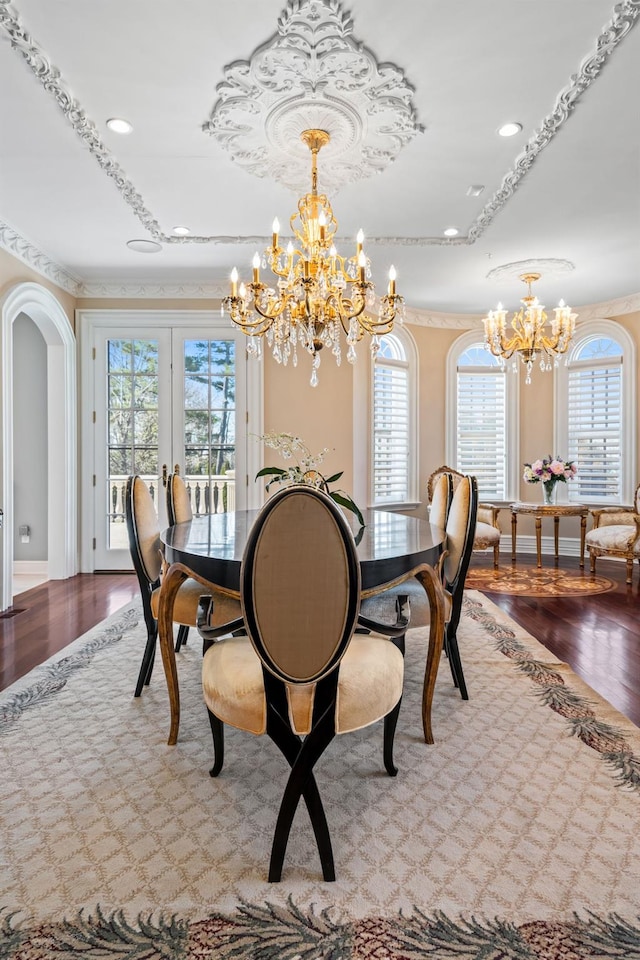 28 Whitney Cir, Glen Cove, NY 11542 - dining space featuring baseboards, arched walkways, an inviting chandelier, and wood finished floors