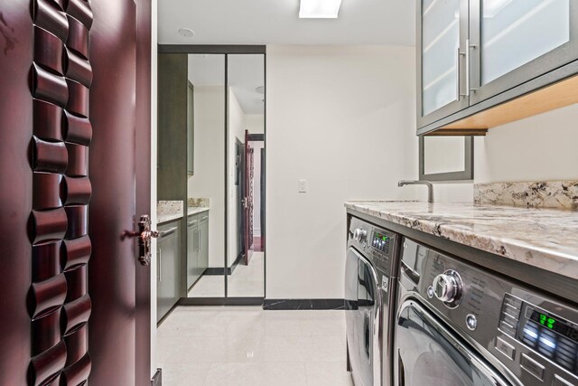 28 Whitney Cir, Glen Cove, NY 11542 - washroom with washing machine and clothes dryer, baseboards, light tile patterned floors, cabinet space, and a sink