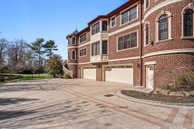 28 Whitney Cir, Glen Cove, NY 11542 - view of front of home featuring brick siding, concrete driveway, an attached garage, and fence