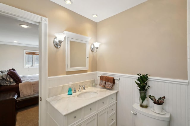 bathroom featuring recessed lighting, a wainscoted wall, vanity, and toilet