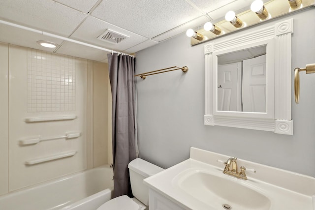 full bath featuring toilet, a paneled ceiling, vanity, visible vents, and shower / tub combo with curtain