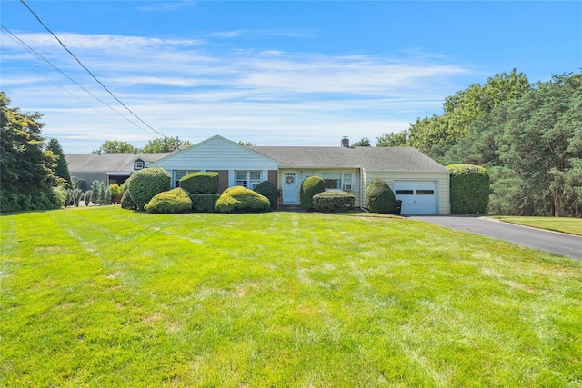 ranch-style house featuring a front lawn, driveway, and an attached garage