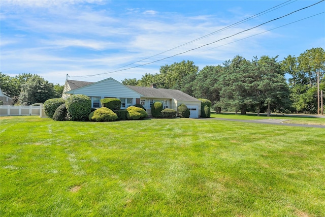 exterior space with a garage, driveway, fence, and a front lawn