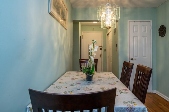 dining space with baseboards, a chandelier, and dark wood-style flooring