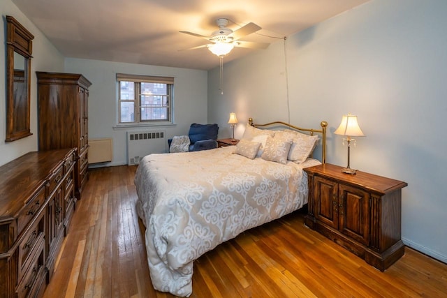 bedroom with a ceiling fan, radiator, and wood-type flooring