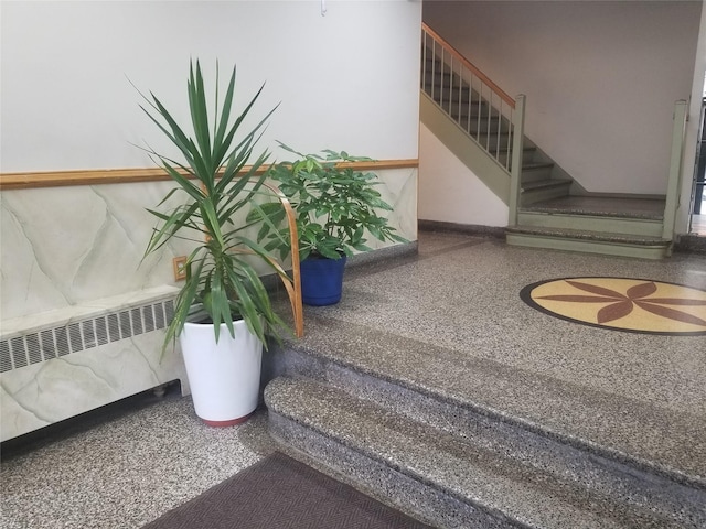 staircase featuring speckled floor and radiator