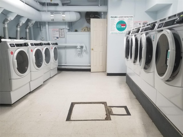 shared laundry area featuring washing machine and clothes dryer and light floors