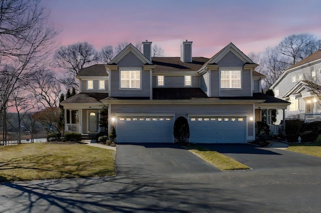 view of front of house with aphalt driveway, a chimney, and an attached garage