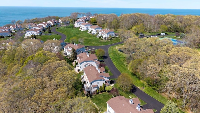 aerial view with a water view, a view of trees, and a residential view