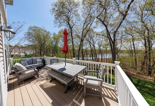 deck with an outdoor living space, a water view, and outdoor dining space