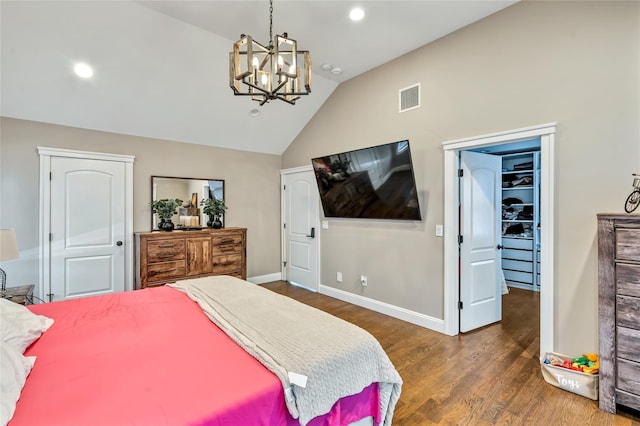 bedroom with lofted ceiling, wood finished floors, visible vents, baseboards, and a closet