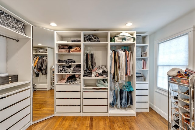 walk in closet with wood finished floors