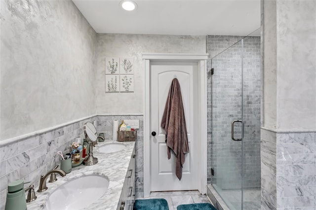 full bath featuring tile walls, a sink, and a shower stall