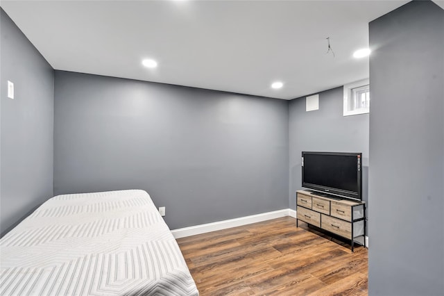 bedroom with recessed lighting, wood finished floors, and baseboards