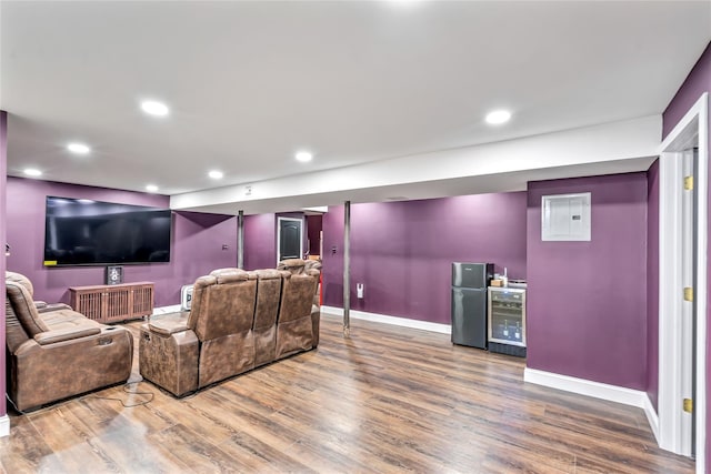 cinema featuring beverage cooler, electric panel, baseboards, wood finished floors, and recessed lighting