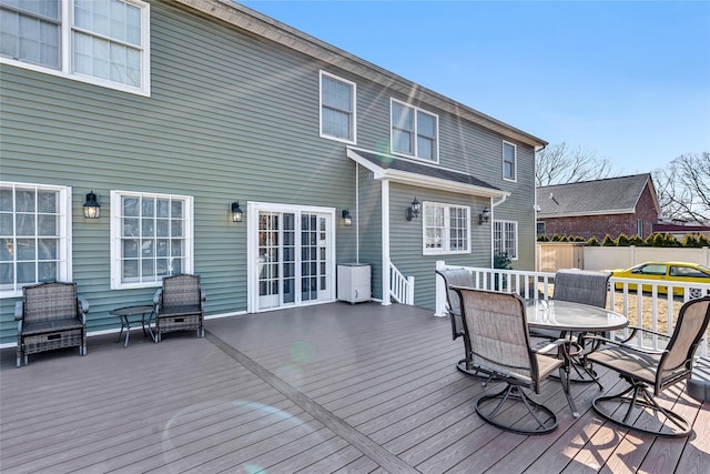 wooden terrace with outdoor dining area and fence