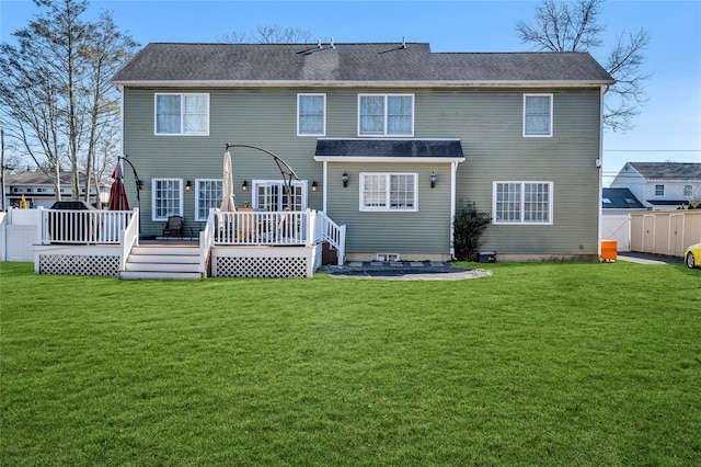 rear view of property with fence, a lawn, and a wooden deck