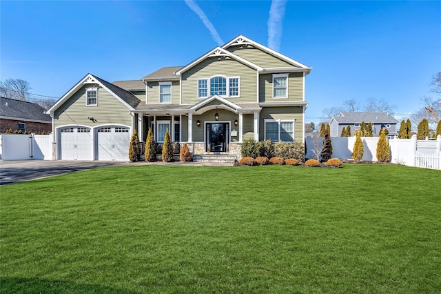 craftsman-style house with driveway, a gate, fence, and a front yard