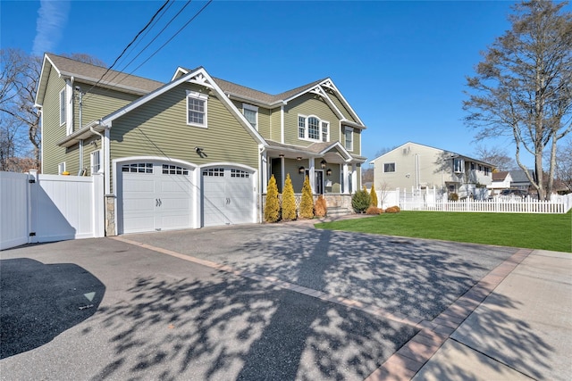 view of front facade with a porch, a garage, fence, a gate, and a front lawn