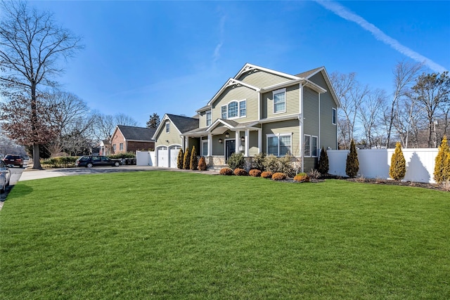 craftsman-style home featuring driveway, a front lawn, an attached garage, and fence