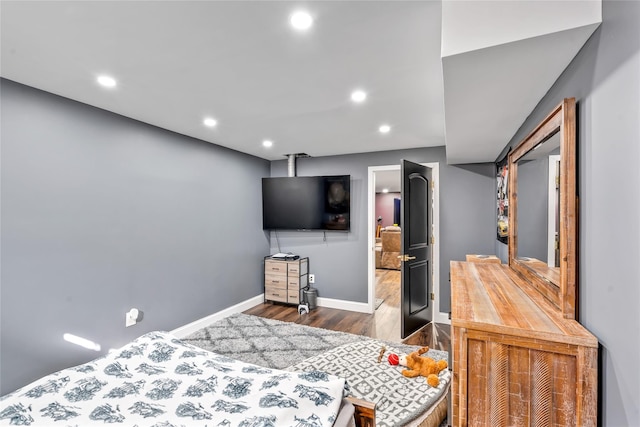 bedroom featuring baseboards, wood finished floors, and recessed lighting