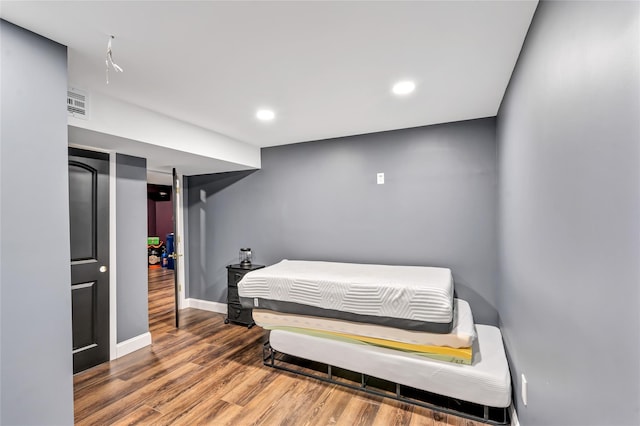 bedroom with recessed lighting, wood finished floors, visible vents, and baseboards