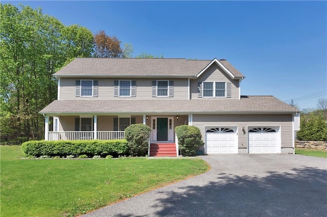 view of front of property featuring driveway, a shingled roof, a porch, and a front yard