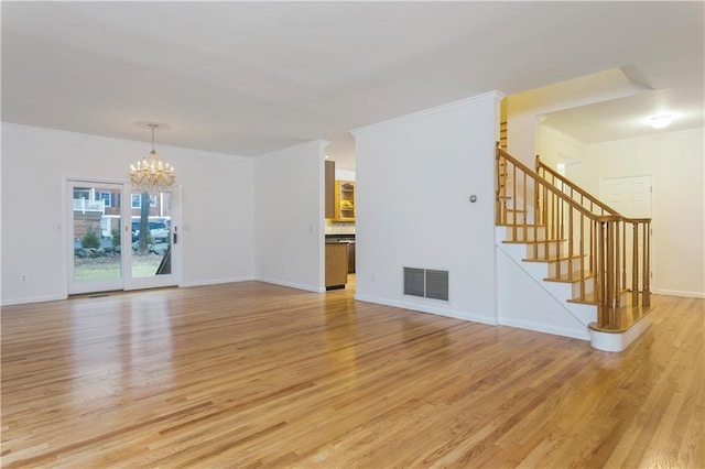 unfurnished living room featuring ornamental molding, a notable chandelier, light wood-style flooring, and stairs