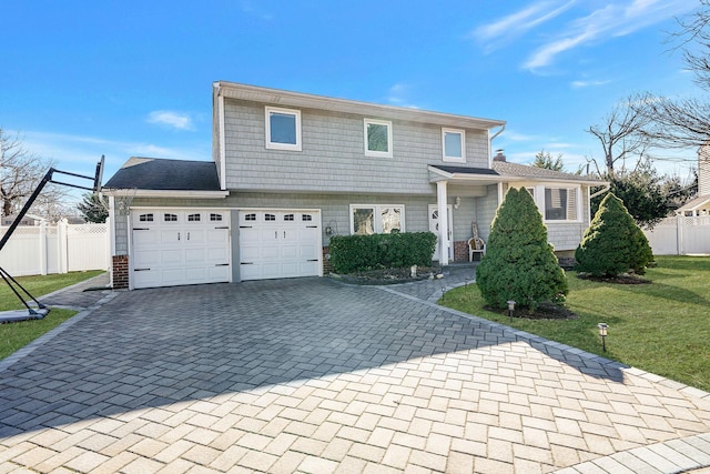 view of front of home with a garage, a front lawn, decorative driveway, and fence