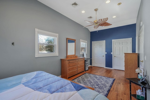 bedroom featuring visible vents, vaulted ceiling, wood finished floors, and recessed lighting