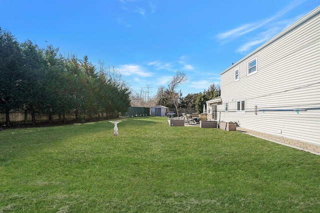 view of yard featuring an outbuilding, fence, and a storage unit