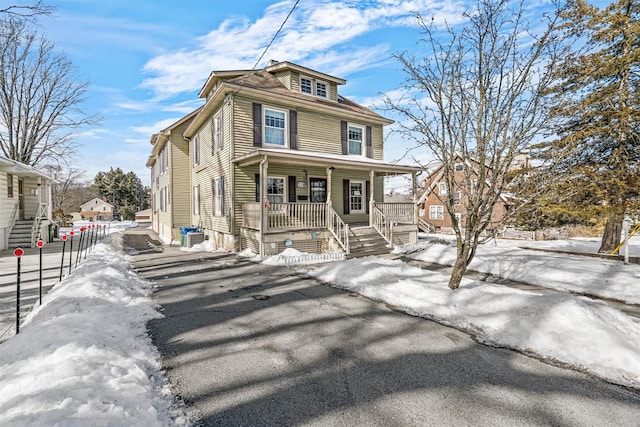 american foursquare style home featuring a porch