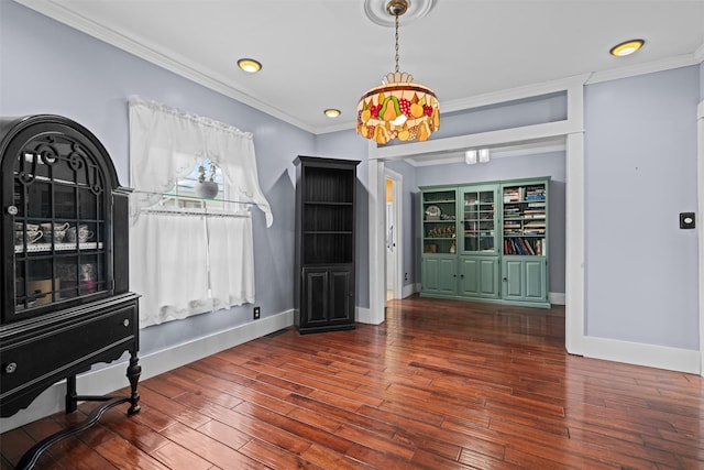 interior space featuring ornamental molding, baseboards, and wood finished floors