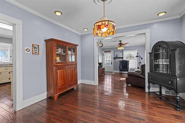 hallway with plenty of natural light, wood-type flooring, ornamental molding, and baseboards