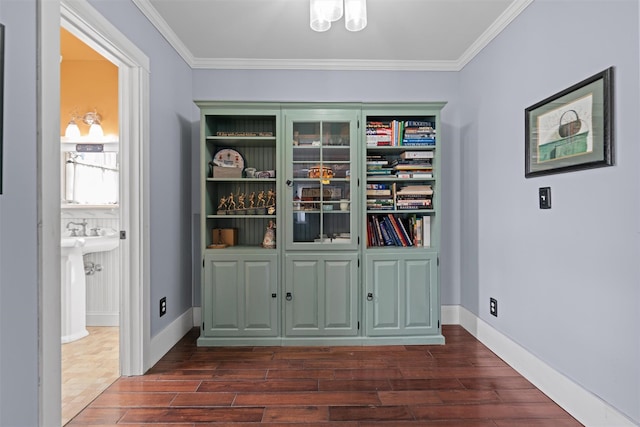 interior space with baseboards, ornamental molding, and wood finished floors