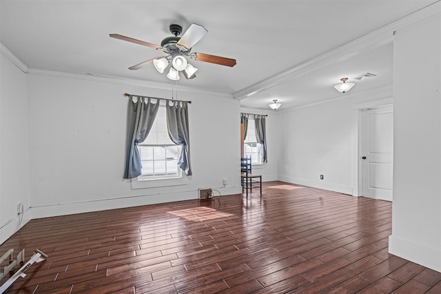 spare room with wood finished floors, visible vents, baseboards, a ceiling fan, and ornamental molding