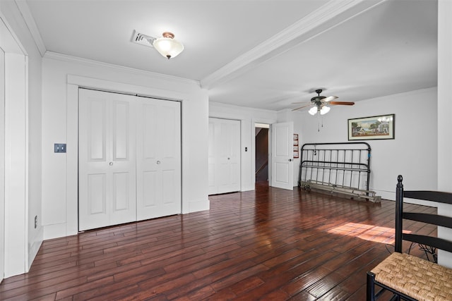 bedroom with hardwood / wood-style flooring, visible vents, baseboards, ornamental molding, and a closet