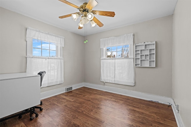 unfurnished office with baseboards, plenty of natural light, visible vents, and wood finished floors