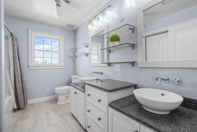 bathroom with baseboards, visible vents, toilet, wood finished floors, and vanity