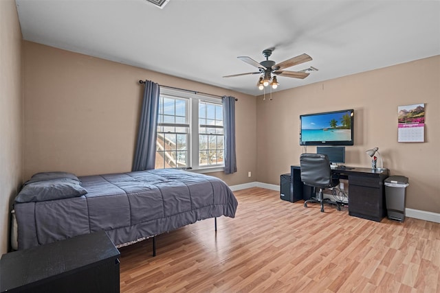 bedroom with a ceiling fan, baseboards, and wood finished floors