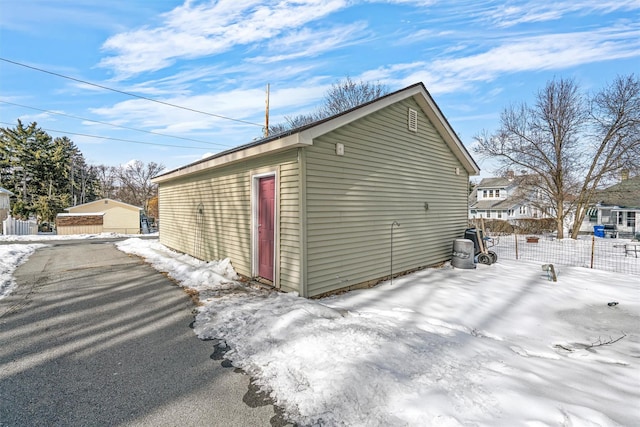 snow covered garage with fence