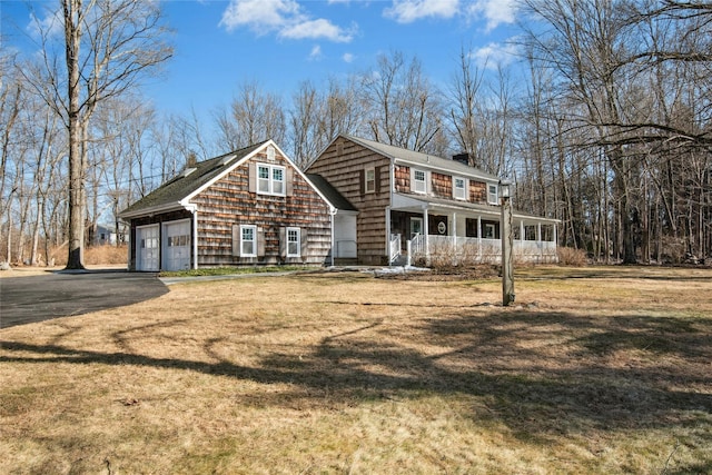 view of front of property featuring a porch, driveway, and a front yard