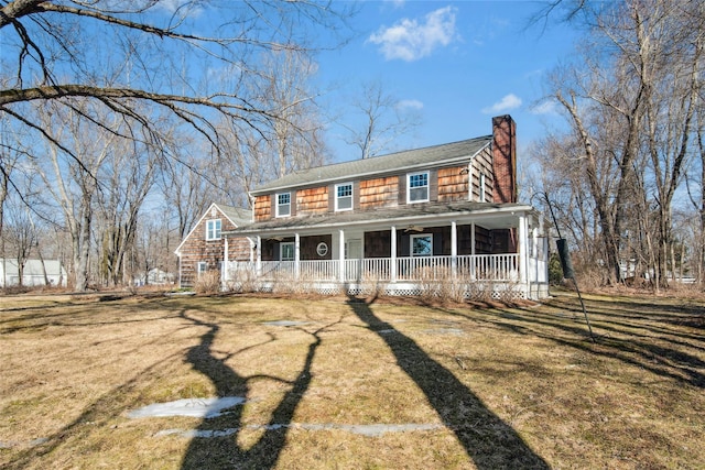 view of front of house featuring a porch, a front lawn, and a chimney